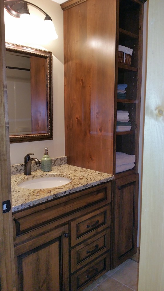 Inredning av ett rustikt mellanstort badrum med dusch, med luckor med upphöjd panel, skåp i mellenmörkt trä, beige väggar, klinkergolv i keramik, ett undermonterad handfat och granitbänkskiva