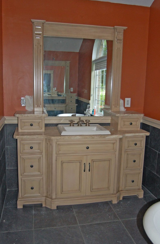 Idée de décoration pour une salle de bain principale tradition en bois clair de taille moyenne avec un placard avec porte à panneau surélevé, une baignoire indépendante, un mur orange, un sol en carrelage de céramique, un lavabo posé et un plan de toilette en granite.