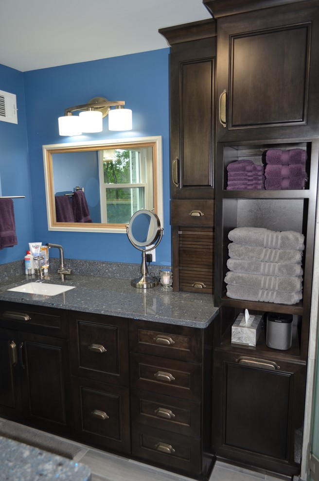 Aménagement d'une salle de bain principale classique en bois foncé de taille moyenne avec un placard à porte shaker, un mur bleu et un plan de toilette en granite.