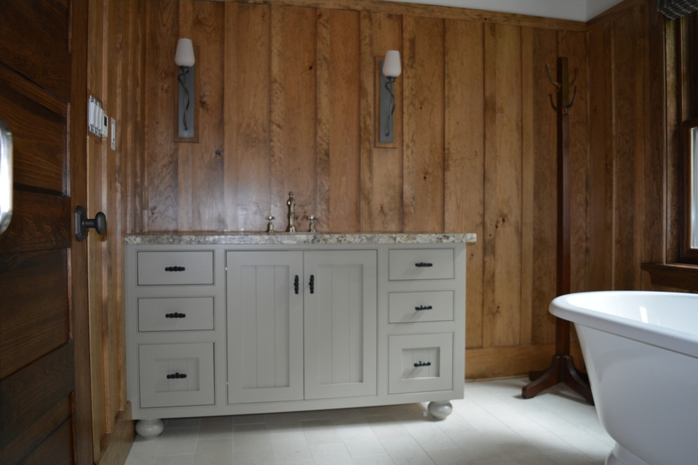 Modelo de cuarto de baño principal rural de tamaño medio con armarios estilo shaker, puertas de armario grises, bañera exenta, paredes marrones, suelo de baldosas de cerámica y encimera de granito