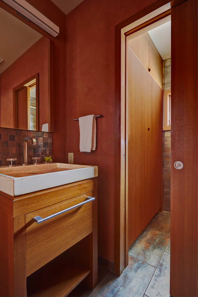 Small contemporary family bathroom in Chicago with freestanding cabinets, light wood cabinets, an alcove shower, a two-piece toilet, brown tiles, metal tiles, orange walls, a vessel sink and engineered stone worktops.