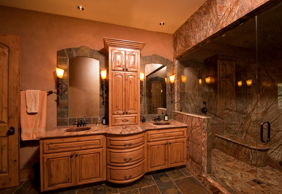 Inspiration pour un sauna chalet en bois vieilli avec un lavabo encastré, un placard avec porte à panneau surélevé, un plan de toilette en marbre, WC à poser, un carrelage marron, un carrelage de pierre, un mur marron et un sol en ardoise.