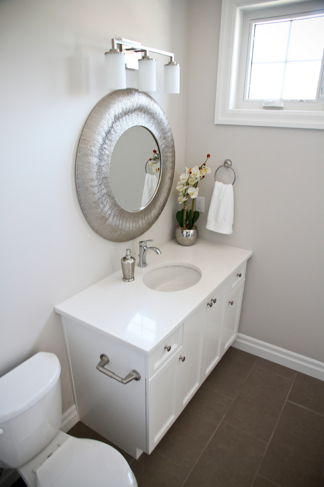 トロントにある低価格の小さなトランジショナルスタイルのおしゃれな浴室 (フラットパネル扉のキャビネット、白いキャビネット、セラミックタイルの床、クオーツストーンの洗面台、茶色い床) の写真