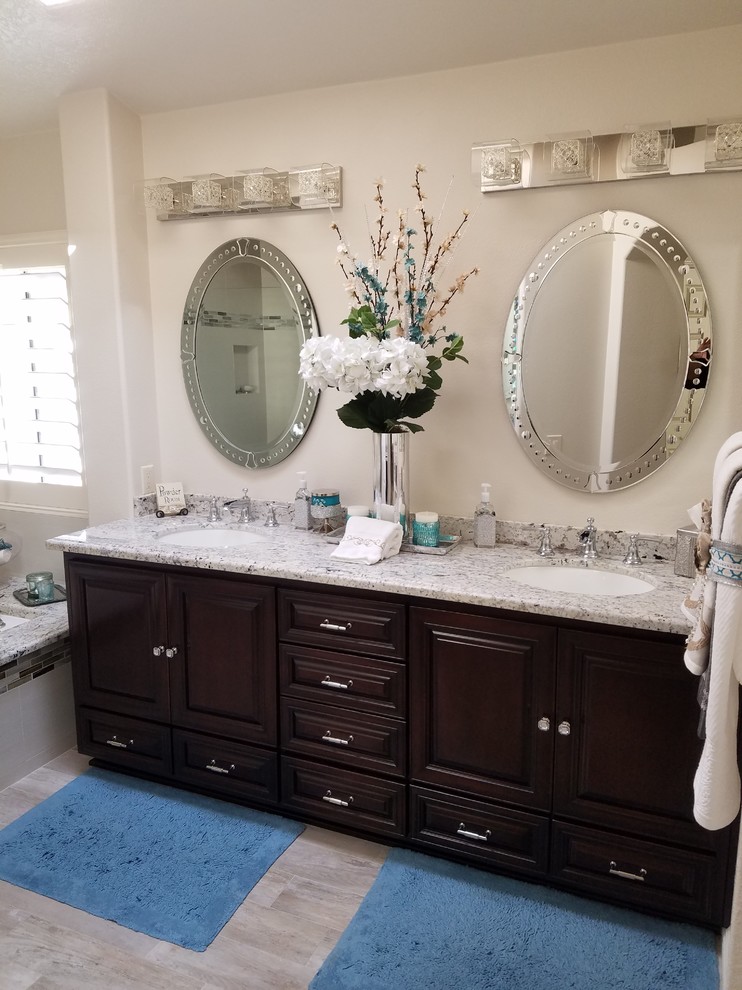 Modelo de cuarto de baño clásico renovado con armarios con paneles con relieve, puertas de armario de madera en tonos medios y encimera de granito
