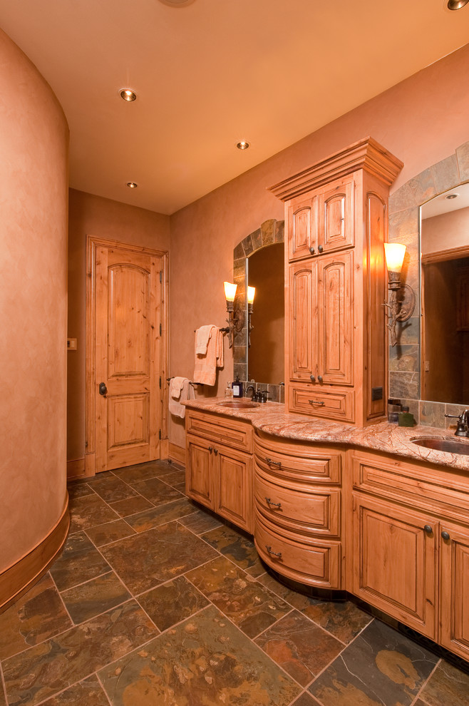 Inspiration för rustika en-suite badrum, med ett undermonterad handfat, luckor med upphöjd panel, skåp i slitet trä, marmorbänkskiva, en toalettstol med hel cisternkåpa, brun kakel, stenkakel, bruna väggar och skiffergolv