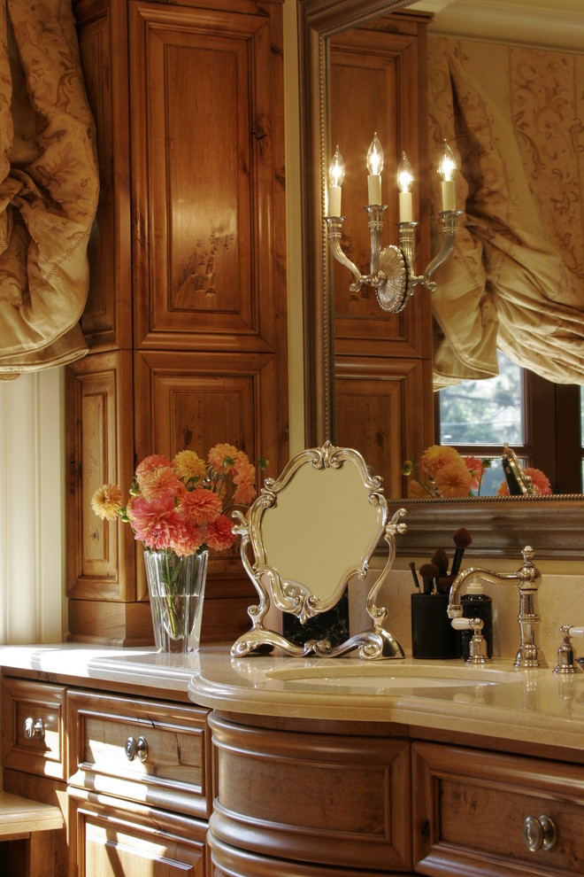 Esempio di un'ampia stanza da bagno padronale mediterranea con lavabo da incasso, ante con bugna sagomata, ante in legno bruno, top in quarzite, piastrelle bianche, piastrelle in metallo e pareti beige