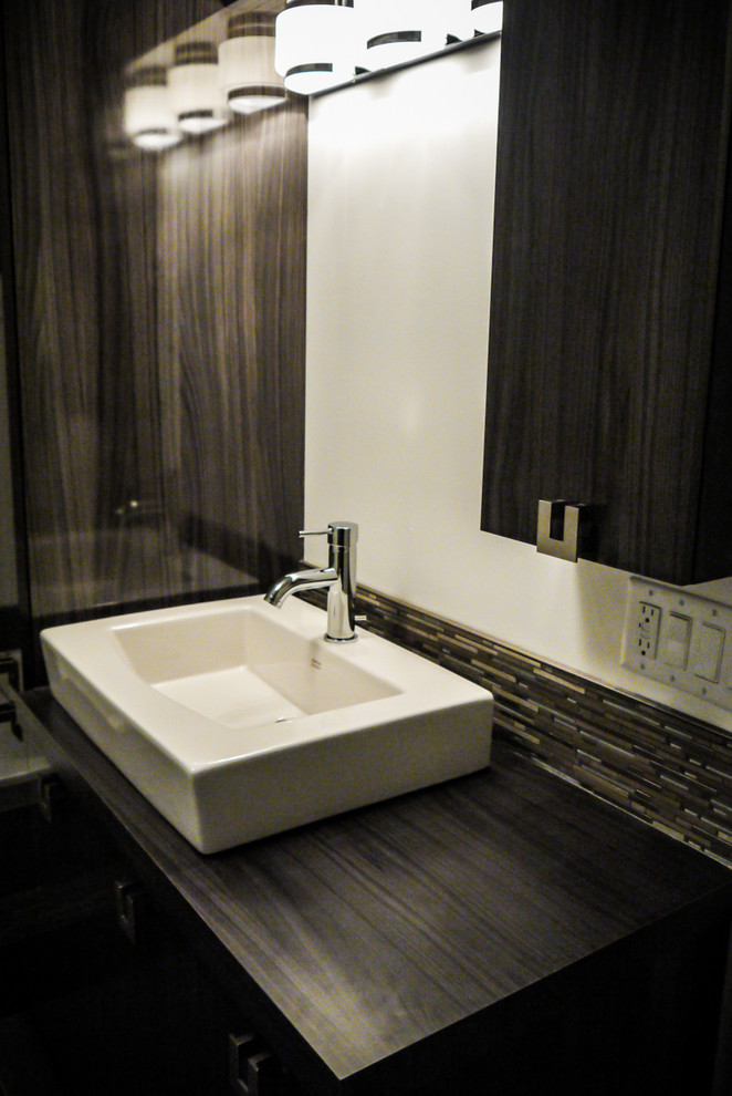Bathroom - contemporary blue tile ceramic tile bathroom idea in Montreal with a console sink, flat-panel cabinets, dark wood cabinets, laminate countertops, a two-piece toilet and white walls