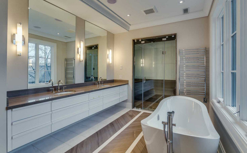 Idéer för att renovera ett stort funkis en-suite badrum, med släta luckor, vita skåp, ett fristående badkar, beige väggar, mellanmörkt trägolv, ett undermonterad handfat och brunt golv