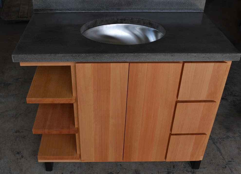 Cette image montre une salle de bain design en bois brun de taille moyenne avec un plan de toilette en béton.