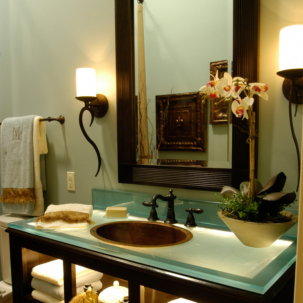 Immagine di una grande stanza da bagno classica con nessun'anta, ante in legno bruno, pareti verdi, lavabo da incasso e top in vetro