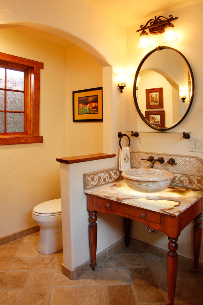Mediterranes Badezimmer mit Aufsatzwaschbecken, verzierten Schränken, hellbraunen Holzschränken, Toilette mit Aufsatzspülkasten, beiger Wandfarbe und Onyx-Waschbecken/Waschtisch in San Francisco