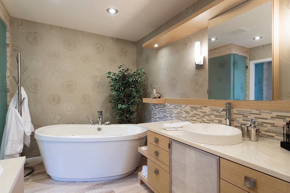 Idée de décoration pour une grande salle de bain principale design en bois clair avec une baignoire indépendante, une vasque, un placard à porte plane, un mur marron et un sol beige.