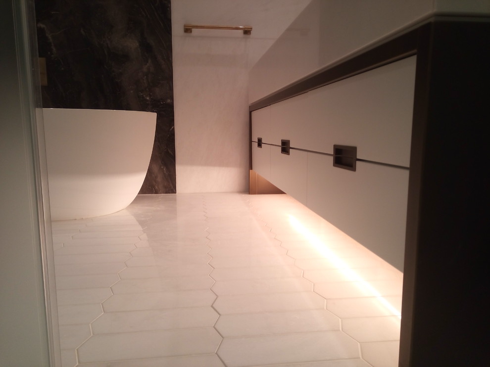 Свежая идея для дизайна: большая главная ванная комната в современном стиле с плоскими фасадами, белыми фасадами, отдельно стоящей ванной, душем в нише, писсуаром, разноцветной плиткой, белой плиткой, плиткой из листового камня, белыми стенами и раковиной с несколькими смесителями - отличное фото интерьера