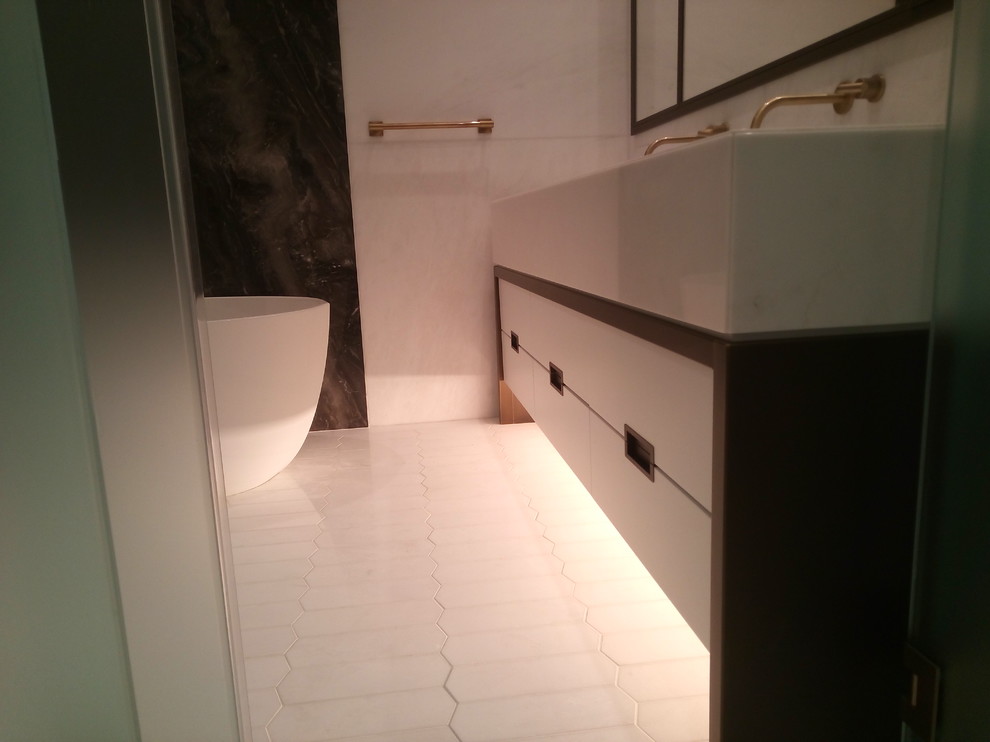 Idéer för stora funkis en-suite badrum, med släta luckor, vita skåp, ett fristående badkar, en dusch i en alkov, ett urinoar, flerfärgad kakel, vit kakel, stenhäll, vita väggar och ett avlångt handfat