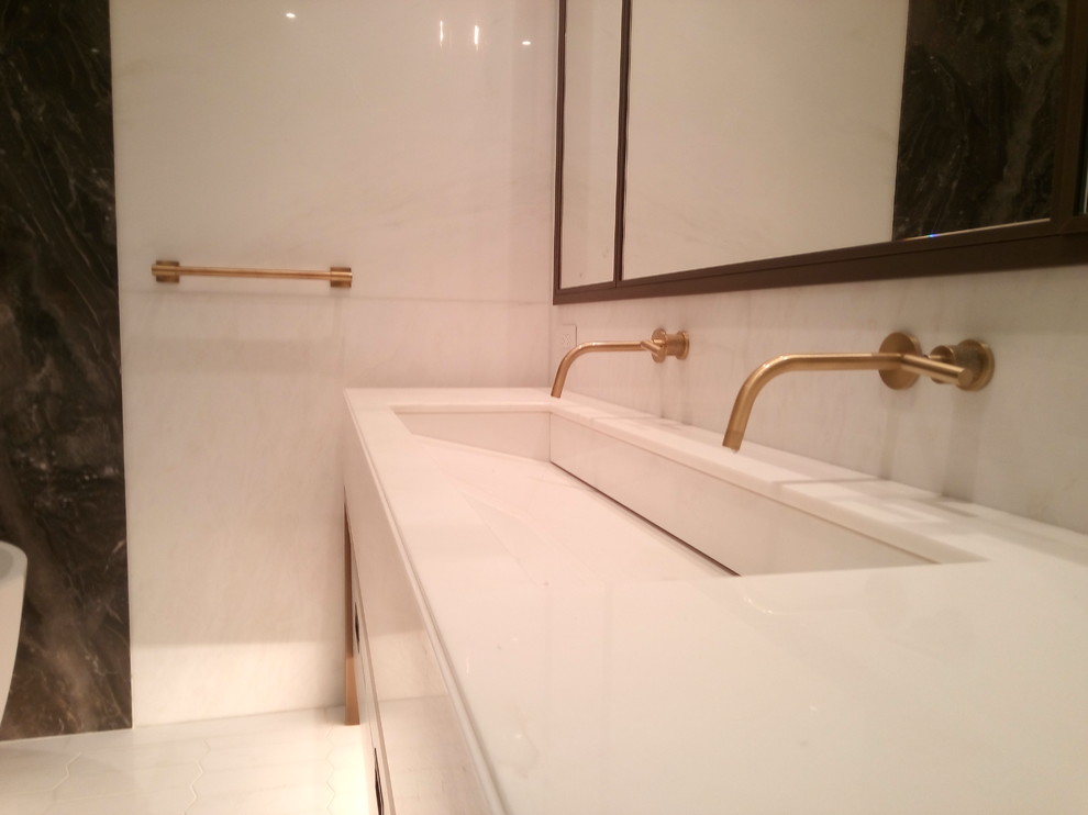 Exempel på ett stort modernt en-suite badrum, med släta luckor, vita skåp, ett fristående badkar, en dusch i en alkov, ett urinoar, flerfärgad kakel, vit kakel, stenhäll, vita väggar och ett avlångt handfat
