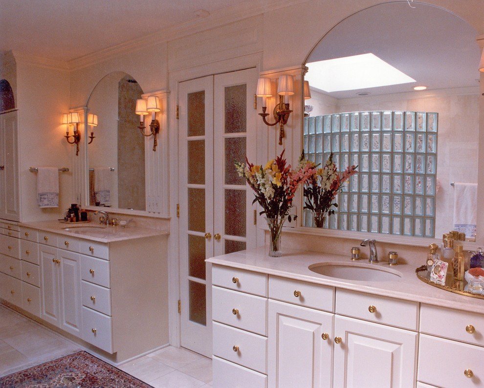 Photo of a classic bathroom in Charlotte with a submerged sink, raised-panel cabinets, white cabinets and solid surface worktops.