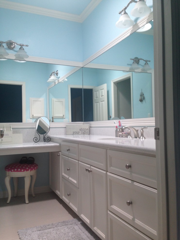 На фото: детская ванная комната среднего размера в классическом стиле с белыми фасадами, синими стенами, полом из ламината, врезной раковиной, столешницей из искусственного камня, бежевым полом и фасадами с утопленной филенкой