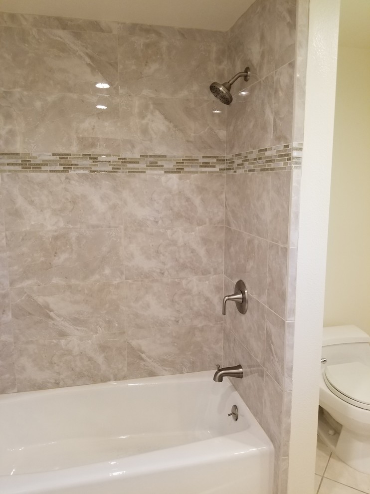 Ejemplo de cuarto de baño tradicional con bañera empotrada, baldosas y/o azulejos beige y baldosas y/o azulejos de porcelana