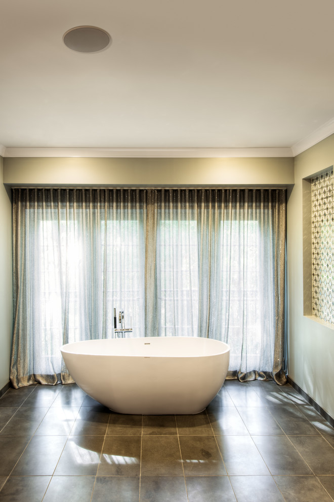 Exemple d'une grande salle de bain principale tendance avec une baignoire indépendante, un carrelage marron, des carreaux de porcelaine, un mur beige, un sol en carrelage de céramique et un sol marron.