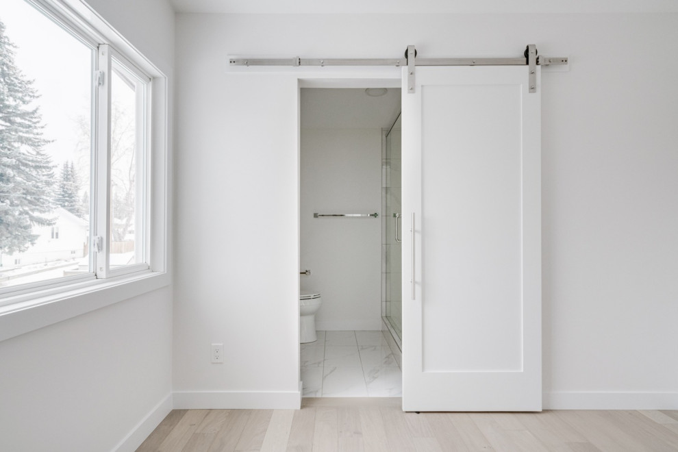 Example of a mid-sized transitional master gray tile, white tile and marble tile marble floor and white floor bathroom design in Calgary with flat-panel cabinets, light wood cabinets, a two-piece toilet, white walls, an undermount sink, quartz countertops, a hinged shower door and white countertops