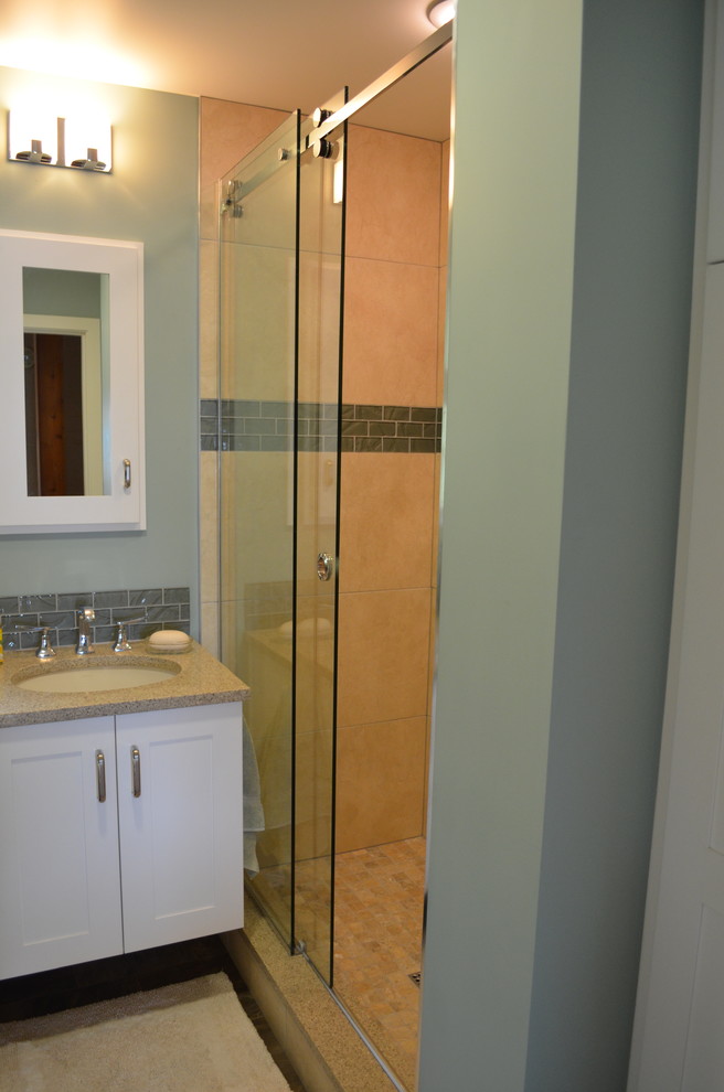 Cette image montre une petite salle de bain marine avec un lavabo encastré, un placard à porte shaker, des portes de placard blanches, un plan de toilette en quartz modifié, WC à poser, un carrelage beige, des carreaux de porcelaine, un mur bleu et un sol en linoléum.