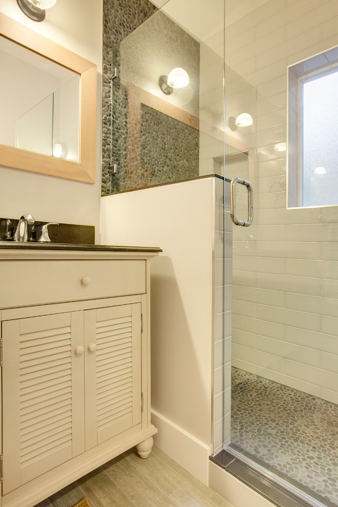 Idee per una stanza da bagno padronale stile marino di medie dimensioni con lavabo sottopiano, ante a persiana, ante con finitura invecchiata, top in quarzo composito, piastrelle bianche, piastrelle di ciottoli, pavimento in gres porcellanato e pareti bianche