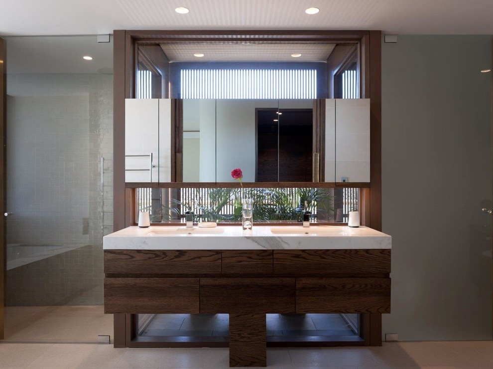 Immagine di una stanza da bagno contemporanea con lavabo sottopiano e pareti grigie