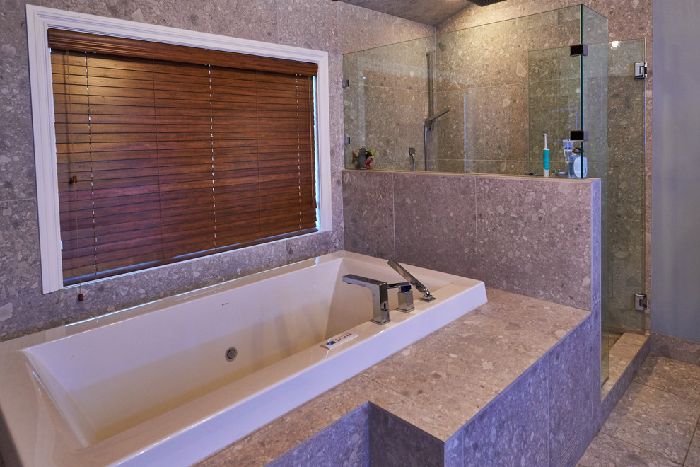 Großes Modernes Badezimmer En Suite mit Einbaubadewanne, Eckdusche, grauen Fliesen, Steinfliesen, grauer Wandfarbe und Porzellan-Bodenfliesen in Calgary