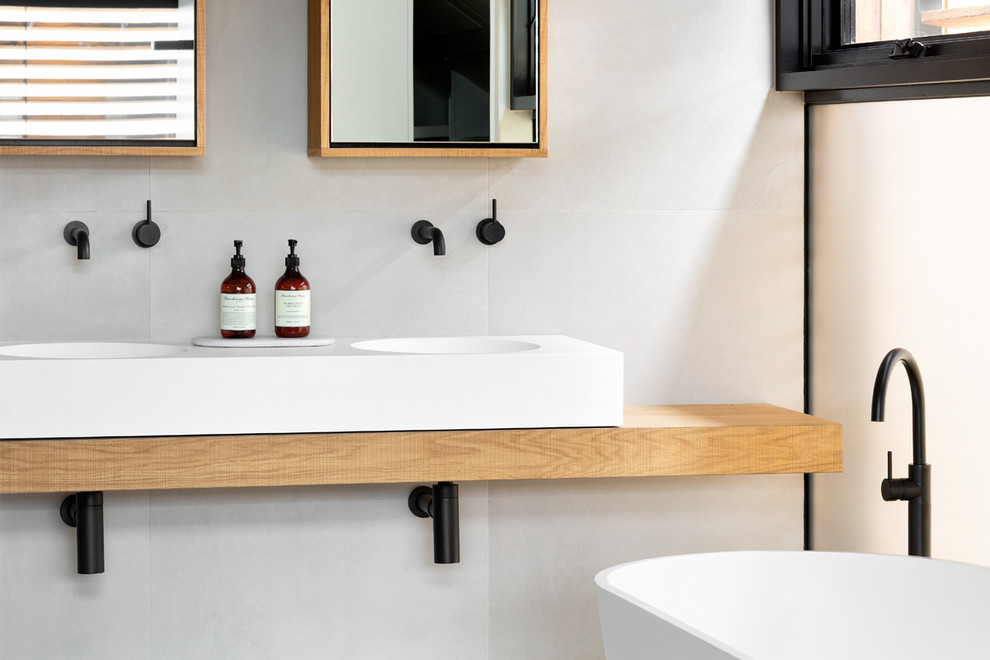 Bild på ett litet funkis brun brunt badrum med dusch, med luckor med glaspanel, ett fristående badkar, en öppen dusch, vita väggar, ett väggmonterat handfat, träbänkskiva och med dusch som är öppen