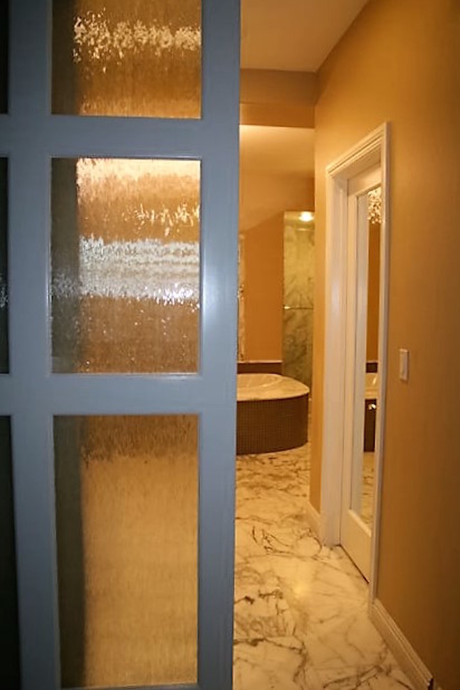 Cette photo montre une grande salle de bain principale chic en bois foncé avec un placard à porte vitrée, une baignoire posée, une douche double, WC à poser, un carrelage gris, un carrelage de pierre, un mur beige, un sol en marbre, une vasque et un plan de toilette en marbre.