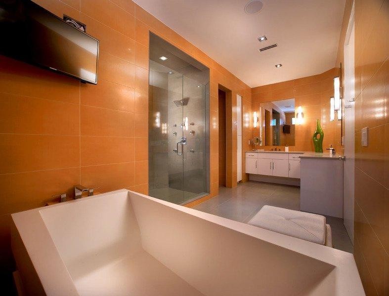 Свежая идея для дизайна: большая главная ванная комната в современном стиле с плоскими фасадами, белыми фасадами, отдельно стоящей ванной, душем в нише, оранжевой плиткой, керамогранитной плиткой, оранжевыми стенами, бетонным полом, серым полом и душем с распашными дверями - отличное фото интерьера