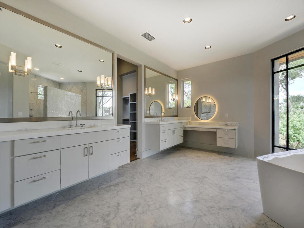 Idee per una grande stanza da bagno padronale design con ante lisce, ante bianche, vasca freestanding, pareti grigie, pavimento in marmo, lavabo sottopiano, top in marmo e pavimento bianco