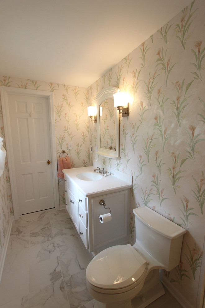 This is an example of a small traditional ensuite bathroom in Cleveland with white cabinets, a corner shower, a one-piece toilet, white tiles, multi-coloured walls, cement flooring, a submerged sink, solid surface worktops, white floors and a hinged door.