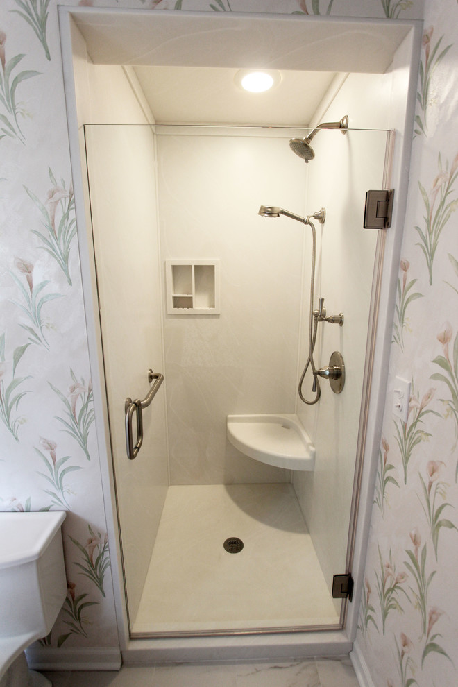 Inredning av ett klassiskt litet en-suite badrum, med vita skåp, en hörndusch, en toalettstol med hel cisternkåpa, vit kakel, flerfärgade väggar, cementgolv, ett undermonterad handfat, bänkskiva i akrylsten, vitt golv och dusch med gångjärnsdörr