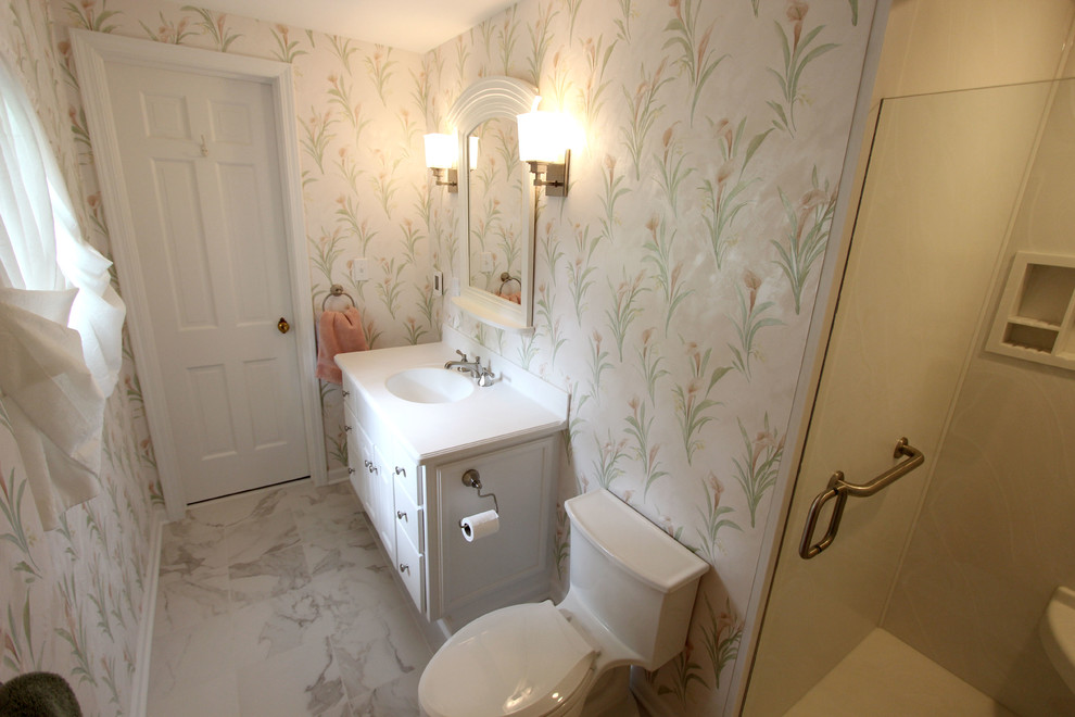 Photo of a small traditional ensuite bathroom in Cleveland with white cabinets, a corner shower, a one-piece toilet, white tiles, multi-coloured walls, cement flooring, a submerged sink, solid surface worktops, white floors and a hinged door.