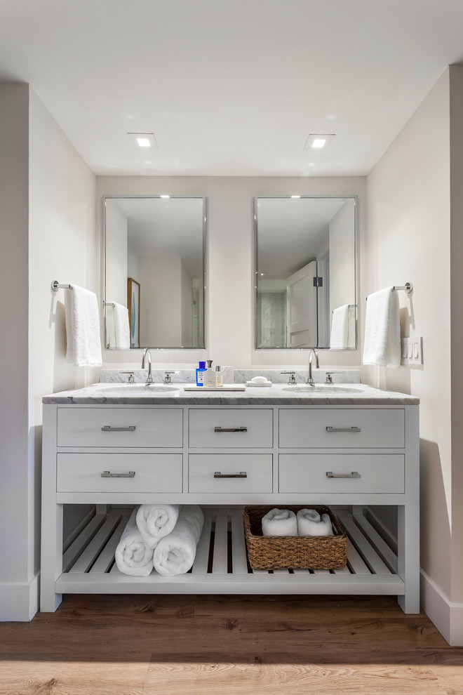 Inspiration för mellanstora klassiska vitt en-suite badrum, med släta luckor, vita skåp, beige kakel, marmorkakel, beige väggar, laminatgolv, ett undermonterad handfat, marmorbänkskiva och beiget golv