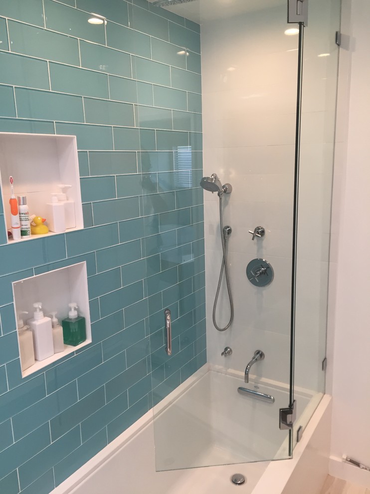 Inredning av ett modernt mellanstort en-suite badrum, med släta luckor, vita skåp, ett fristående badkar, blå kakel, glaskakel, vita väggar och klinkergolv i keramik