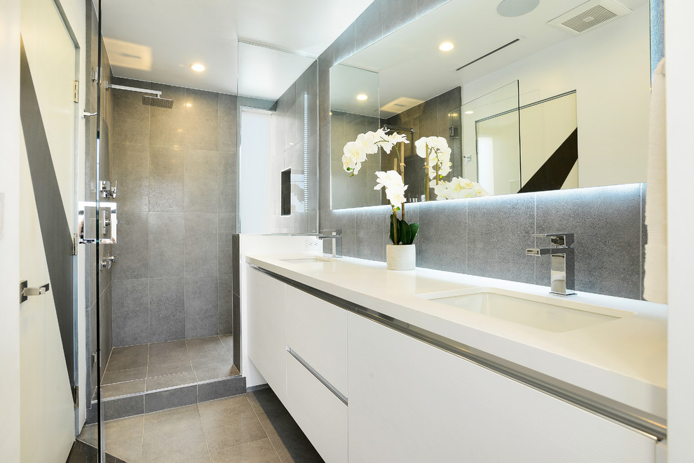 Свежая идея для дизайна: главная ванная комната в современном стиле с плоскими фасадами, белыми фасадами, душем в нише, серой плиткой, врезной раковиной, душем с распашными дверями и зеркалом с подсветкой - отличное фото интерьера