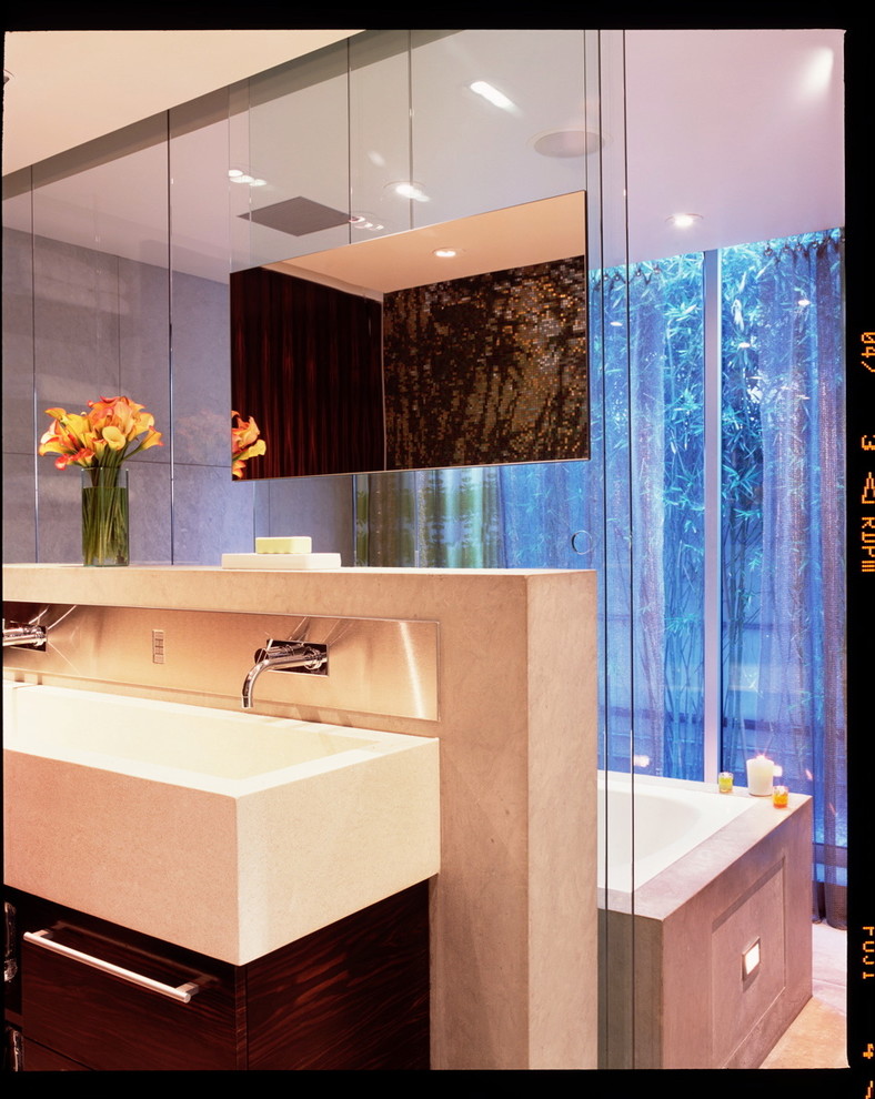 Imagen de cuarto de baño principal contemporáneo de tamaño medio con armarios con paneles lisos, puertas de armario de madera oscura, bañera encastrada, lavabo de seno grande y encimera de cuarzo compacto