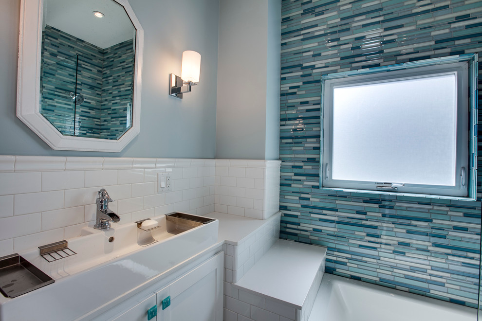 На фото: ванная комната в стиле неоклассика (современная классика) с раковиной с несколькими смесителями, фасадами в стиле шейкер, белыми фасадами, синей плиткой и удлиненной плиткой