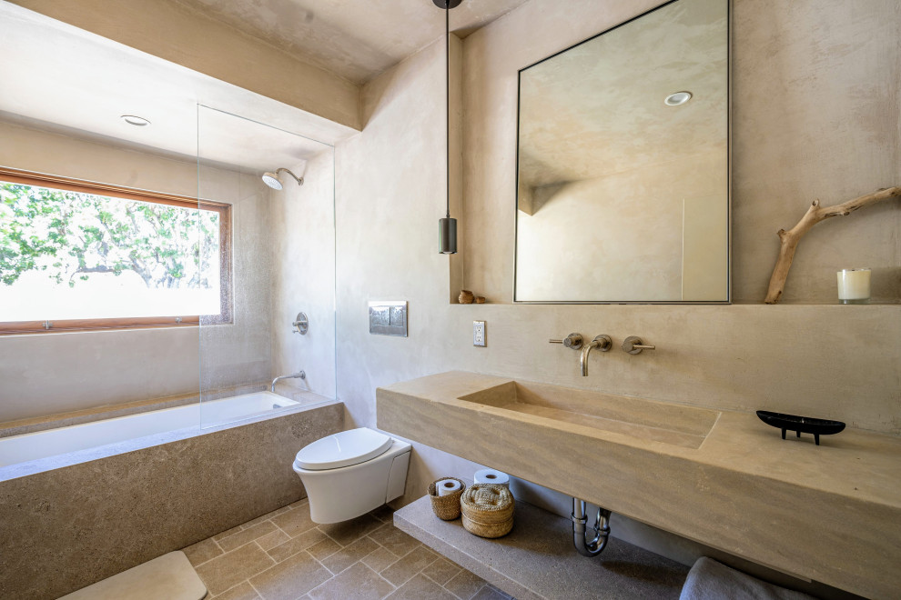 Cette photo montre une salle de bain sud-ouest américain avec une baignoire en alcôve, un combiné douche/baignoire, un mur beige, un lavabo intégré, un sol beige, aucune cabine, un plan de toilette beige, meuble simple vasque et meuble-lavabo suspendu.