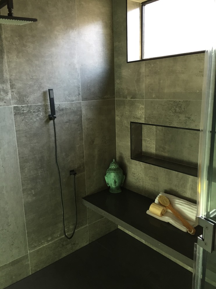 Modern inredning av ett stort en-suite badrum, med släta luckor, skåp i ljust trä, ett fristående badkar, en dusch i en alkov, grå kakel, cementkakel, grå väggar, cementgolv, ett undermonterad handfat, bänkskiva i akrylsten, grått golv och dusch med gångjärnsdörr
