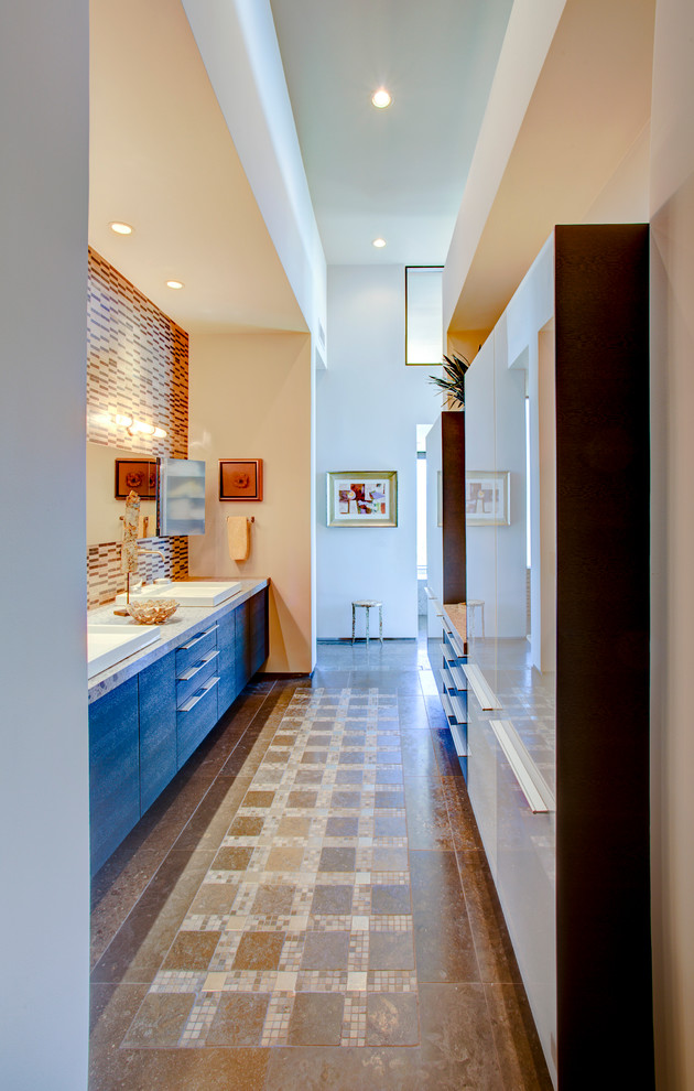 フェニックスにある広いコンテンポラリースタイルのおしゃれな浴室 (フラットパネル扉のキャビネット、グレーのキャビネット、ベージュのタイル、茶色いタイル、ボーダータイル、ベージュの壁、コンクリートの床、オーバーカウンターシンク、茶色い床) の写真