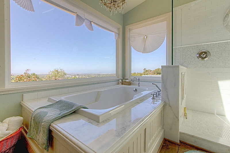 Inspiration for an expansive traditional ensuite bathroom in Santa Barbara with shaker cabinets, white cabinets, a built-in bath, a corner shower, a two-piece toilet, white tiles, ceramic tiles, blue walls, medium hardwood flooring, a built-in sink and marble worktops.