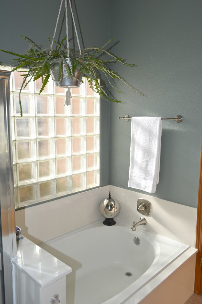 Exempel på ett stort amerikanskt en-suite badrum, med ett integrerad handfat, luckor med upphöjd panel, skåp i mellenmörkt trä, bänkskiva i akrylsten, ett hörnbadkar, en hörndusch, en toalettstol med separat cisternkåpa, beige kakel, keramikplattor, grå väggar och klinkergolv i keramik