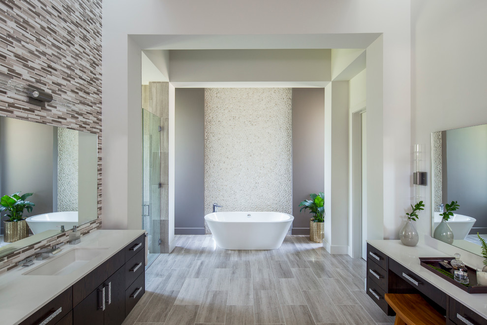 オースティンにあるコンテンポラリースタイルのおしゃれなマスターバスルーム (濃色木目調キャビネット、置き型浴槽、マルチカラーのタイル、モザイクタイル、グレーの壁、アンダーカウンター洗面器) の写真