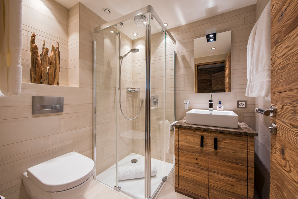 Cette image montre une salle d'eau design en bois brun avec un placard à porte plane, une douche d'angle, WC suspendus, un carrelage beige, un mur beige, parquet en bambou, une vasque, un sol beige, une cabine de douche à porte battante et un plan de toilette marron.