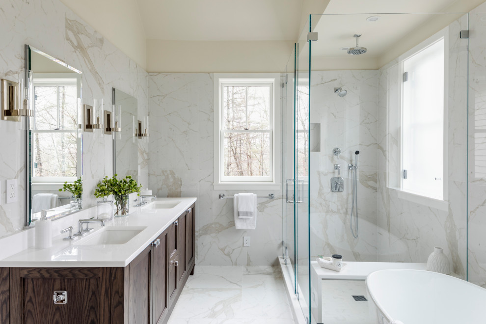 Inspiration for a large country master multicolored tile and marble tile marble floor and multicolored floor bathroom remodel in Boston with recessed-panel cabinets, dark wood cabinets, a one-piece toilet, beige walls, a console sink, quartzite countertops, a hinged shower door and white countertops