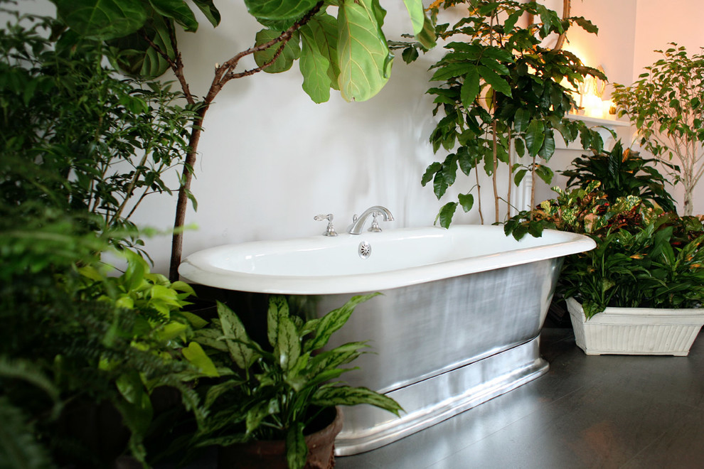 Immagine di una stanza da bagno padronale tropicale con vasca freestanding e pavimento in ardesia