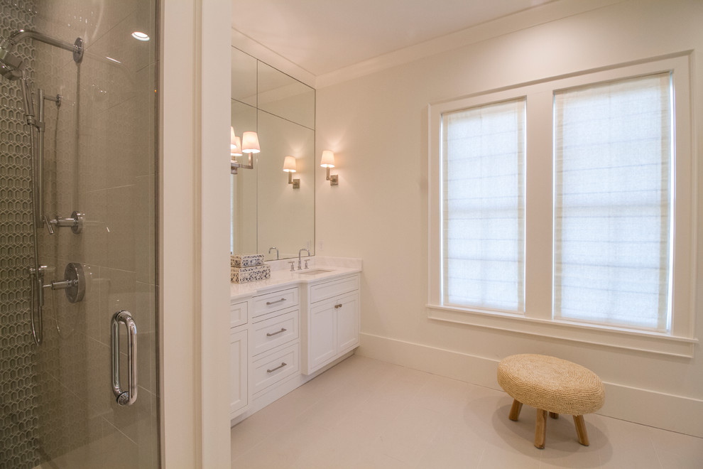 Cette image montre une grande douche en alcôve principale marine avec un placard à porte shaker, des portes de placard blanches, une baignoire indépendante, un mur blanc et un lavabo encastré.